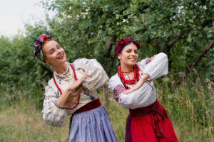 Dwie członkinie zespołu ludowego w tradycyjnych strojach, prezentujące folklor regionu